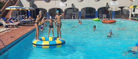 Una piscina al aire libre de temporada, sombrillas, tumbonas