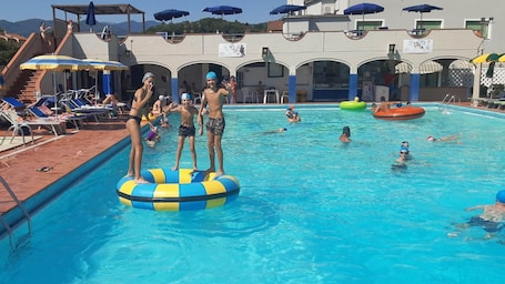 Una piscina al aire libre de temporada, sombrillas