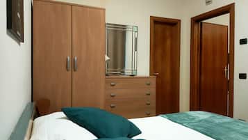 Ein Schlafzimmer mit einem Bett, einem Schminktisch, einem Spiegel und zwei Türen.