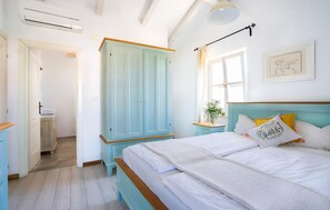 A bedroom with a bed, a wardrobe, a bedside table, a lamp, and a window. - Awesome home in Pula with sauna (Pula)