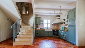 A kitchen with a staircase, green cabinets, and a tiled floor. - Awesome home in Pula with sauna (Pula)