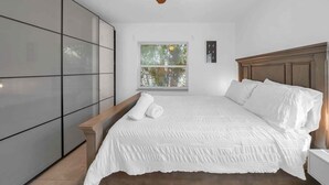A bedroom with a bed, a ceiling fan, a window with blinds, and a wardrobe. - Biscayne Shore-Stylish 3BR Tropical Family Retreat (Miami)