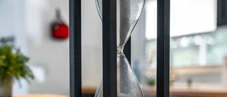 A modern hourglass with a black frame on a polished floor.