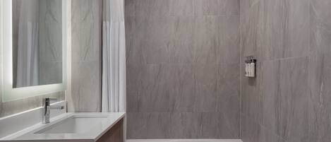 A modern bathroom with a bathtub, a vanity with a mirror, and a shower area with a curtain.