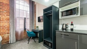 A compact kitchen with a microwave, a kettle, and a wine bottle on the counter. - Stylish 1-bed Studio - Heart of Nottingham (Nottingham)