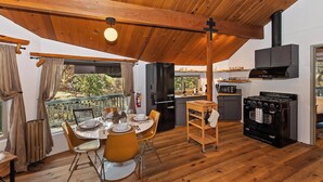 Een gezellig chalet met een eethoek, keuken en een balkon met uitzicht.