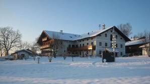 Un grand bâtiment à plusieurs étages, doté d’un toit en pente et entouré de neige.