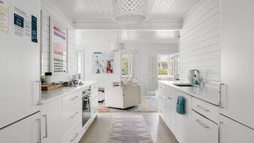 A modern kitchen with white cabinetry, a central island, and a patterned rug.