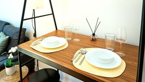 A dining table set with plates, cutlery, and glasses, with a lamp and candles in the background. - Charming 2-bed Apartment in London (London)
