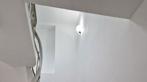 A staircase with a metal railing and a light fixture at the top. - Lambo's Corner  (Varna)