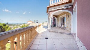A balcony with a view of the sea and buildings, featuring a tiled floor and a railing. - Beautiful home in Dénia (Dénia)