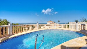 A swimming pool with a clear view of the sea and a building in the background. - Beautiful home in Dénia (Dénia)