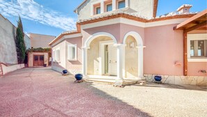 A building with a pink facade, white columns, and a tiled roof. - Beautiful home in Dénia (Dénia)