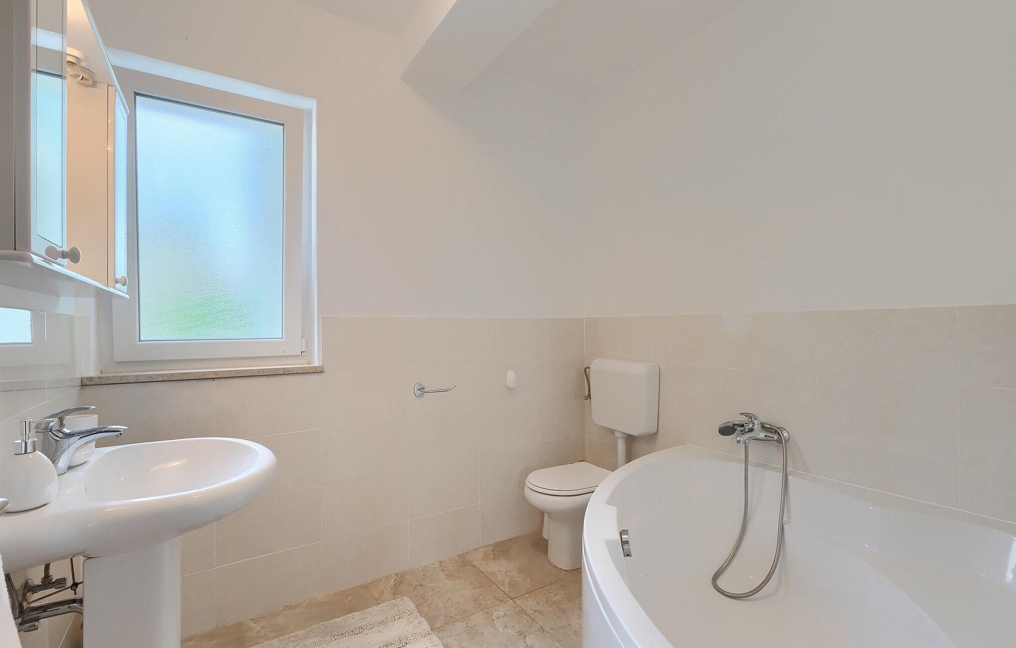 A bathroom with a sink, toilet, and bathtub.