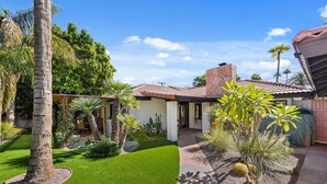 A house with a patio, palm trees, and a well-maintained lawn. - Mountain Views, Heated Pool and Spa (Palm Springs)