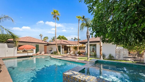 A pool area with a tiled edge, lounge chairs, and a covered seating area. - Mountain Views, Heated Pool and Spa (Palm Springs)