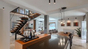 A modern interior with a central island, a staircase, and a dining area. - Stunning home in Pula (Pula)