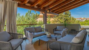 A covered outdoor seating area with wicker furniture, a table, and a ceiling fan. - Stunning home in Pula (Pula)