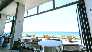 A terrace with tables and chairs overlooking the sea. - TANA Beach Villas (Lian)