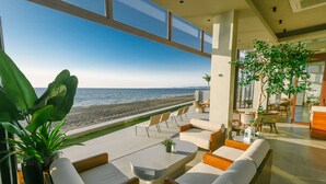 A modern outdoor seating area with a view of the beach and ocean. - TANA Beach Villas (Lian)