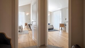 A modern apartment with a wooden floor, a dining area with a table and chairs, a bed, and a bathroom with a mirror and sink. - Awesome home in Porec (Porec)