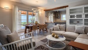 A modern living room with a sofa, coffee table, and dining area. - Awesome home in Porec (Porec)