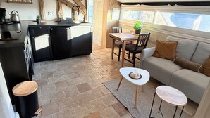 Un espace de vie compact comprenant une kitchenette, un coin repas et un espace détente.