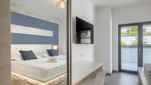 Un dormitorio moderno con cama, mesita de noche y un ventanal grande.