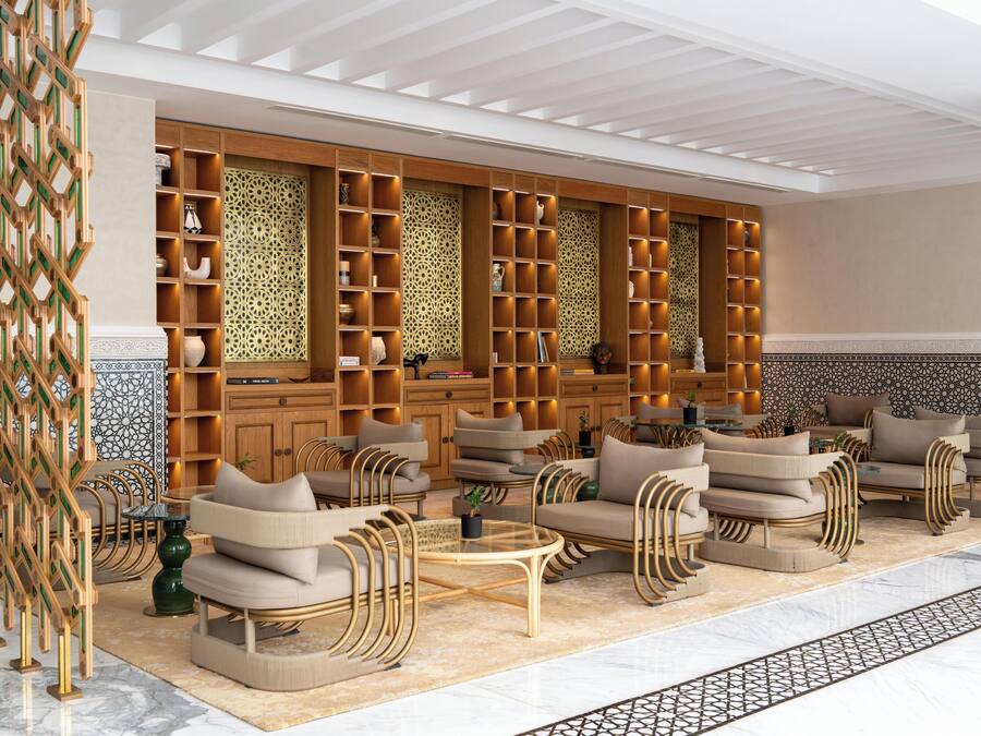A modern lobby with seating areas, wooden shelving with decorative items, and patterned wall designs.