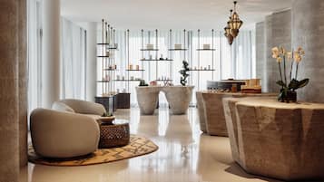 A modern interior with a central seating area, a coffee table, and a decorative plant.