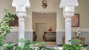 A lobby with a receptionist, ornate columns, patterned tiles, and large vases. - Four Seasons Hotel Rabat At Kasr Al Bahr (Rabat)