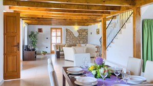 A dining area with a wooden ceiling, stone wall, and a staircase. - Beautiful home in Rovinj (Rovinj)