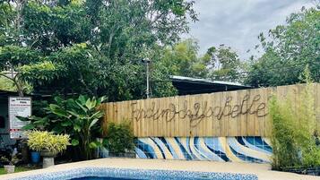 A swimming pool with a wooden fence and a sign that reads "Gardin Dall'selle."