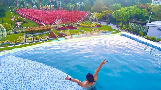 A swimming pool with a tiled edge and a person in the water.