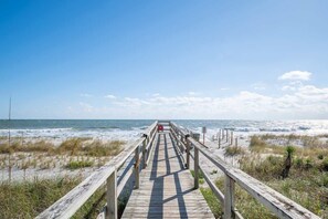 A wooden boardwalk leading to the beach with a clear view of the ocean. - Sea La Vie Cottage Retreat (Kure Beach)