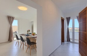 A modern dining area with a long table, four chairs, and a view of the outdoors. - Beautiful home in Pula (Pula)