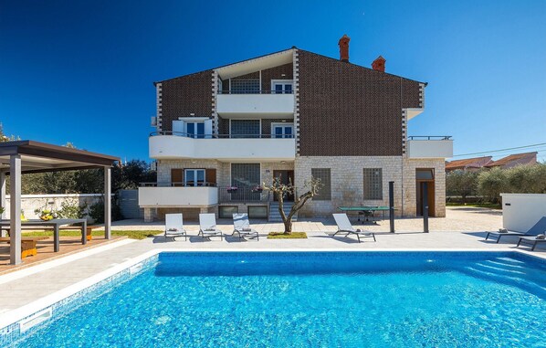 A two-story house with a swimming pool, outdoor seating, and a garden. - Beautiful home in Pula (Pula)