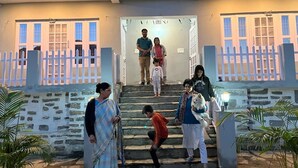 A building entrance with a stone facade, a white picket fence, and a staircase leading up. - Khaltaal Camp And Resorts (Chamoli)