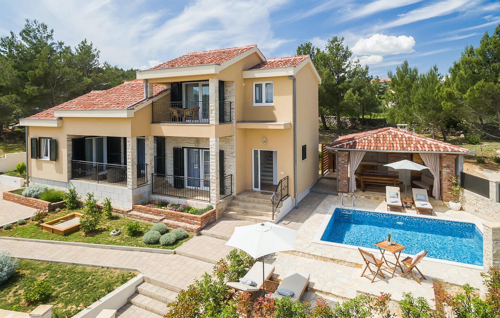 A two-story house with a swimming pool, outdoor seating, and a covered patio.