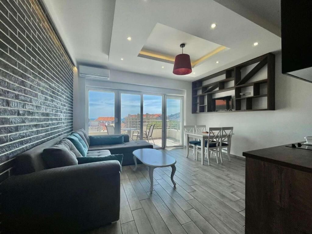 Ein modernes Wohnzimmer mit einer Couch, einem Couchtisch und einem Essbereich mit Tisch und Stühlen.