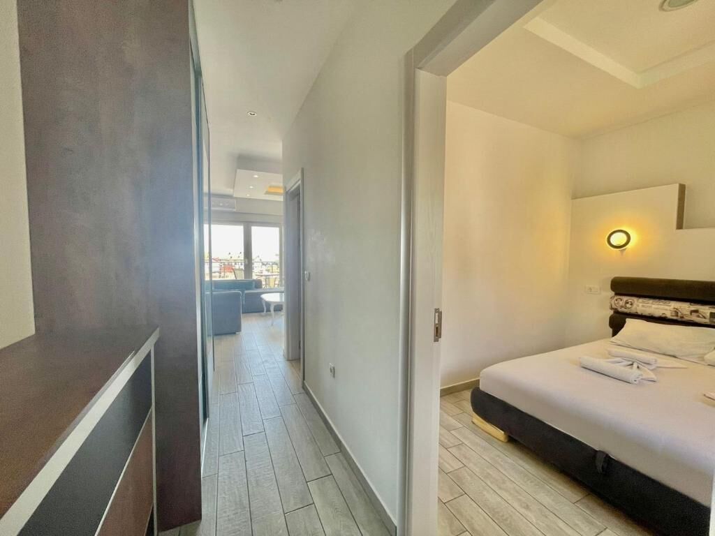 Habitación de hotel con cama, escritorio y vista a la ciudad desde la ventana.