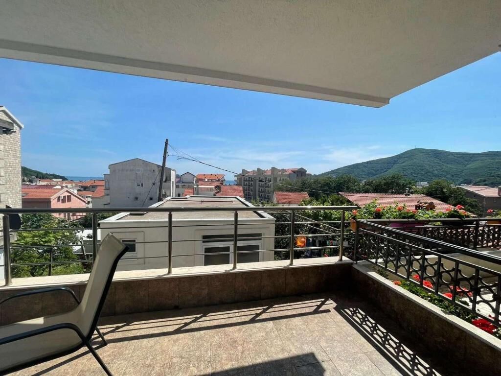 A balcony with a view of buildings and hills.