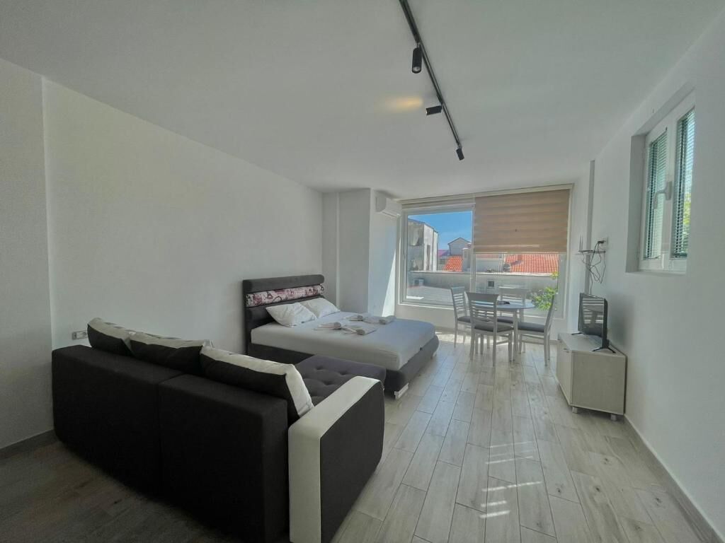 Een moderne slaapkamer met een bed, een bank, een bureau en een stoel.