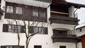 Un edificio de varios pisos con características arquitectónicas tradicionales, como balcones y contraventanas de madera.