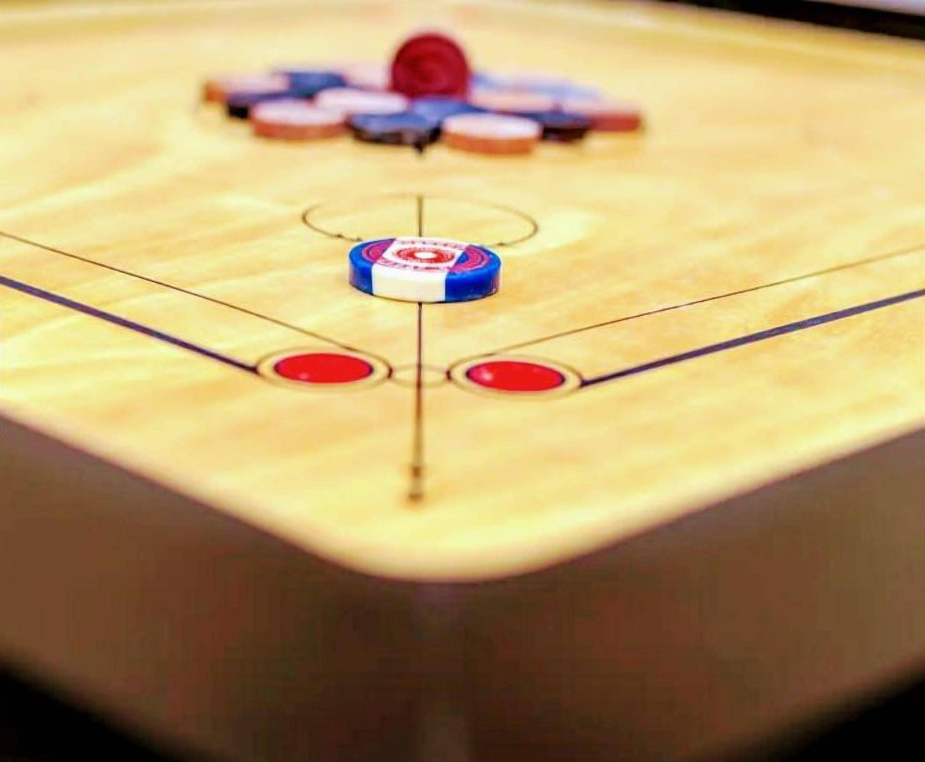 Une vue rapprochée d’une table de jeu de palet, avec des palets et un logo.