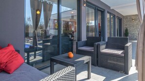 A modern outdoor seating area with wicker furniture and a glass partition. - Stunning home in Svetvincenat (Svetvincenat)