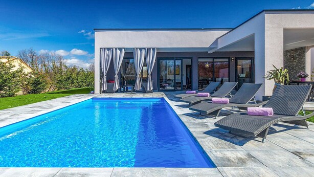 A modern house with a swimming pool, outdoor seating, and a view of the surrounding landscape. - Stunning home in Svetvincenat (Svetvincenat)