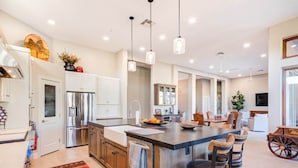 A modern kitchen with a central island, stainless steel appliances, and pendant lighting. - Luxury Retreat with Heated Pool in Scottsdale (Scottsdale)
