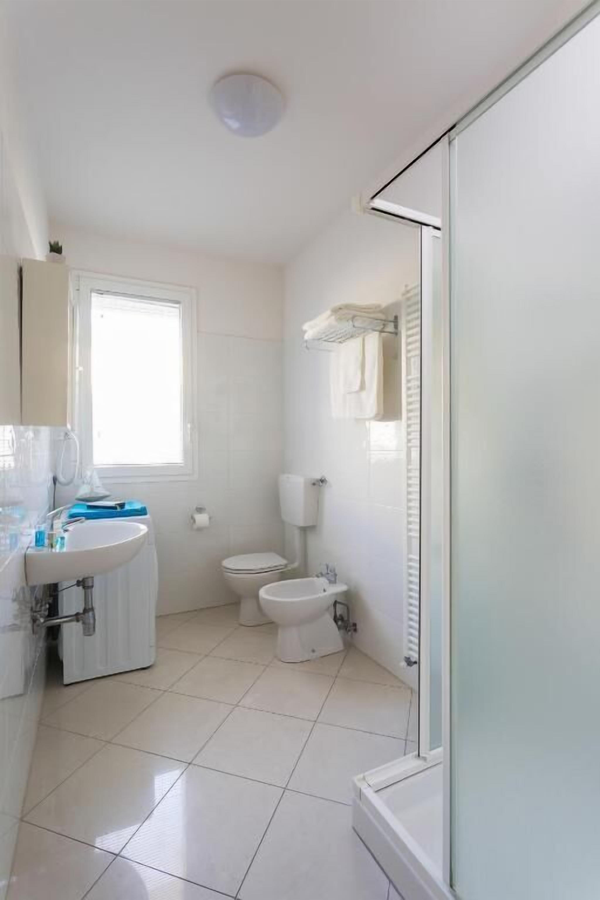 Un bagno piccolo e pulito, con toilette, lavandino e doccia.