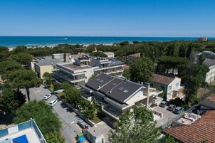 Vista aérea de una zona residencial con edificios modernos, un estacionamiento y vistas al mar.